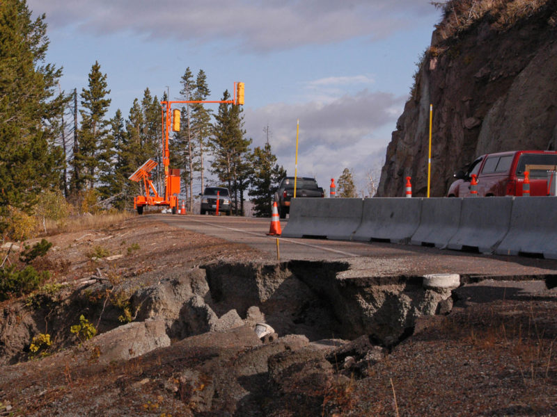 Traffic in 2012 moves along a single lane of the then-damaged road between Sylvan Pass and Fishing Bridge in Yellowstone National Park.