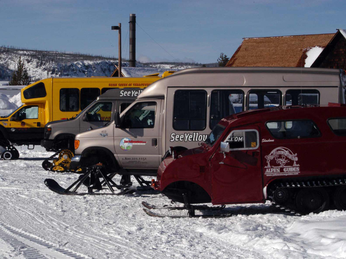 Snow coaches operated by private tour guide companies are parked near Old Fiathful Geyser in Yellowstone National Park. (Ruffin Prevost/Yellowstone Gate - click to enlarge)