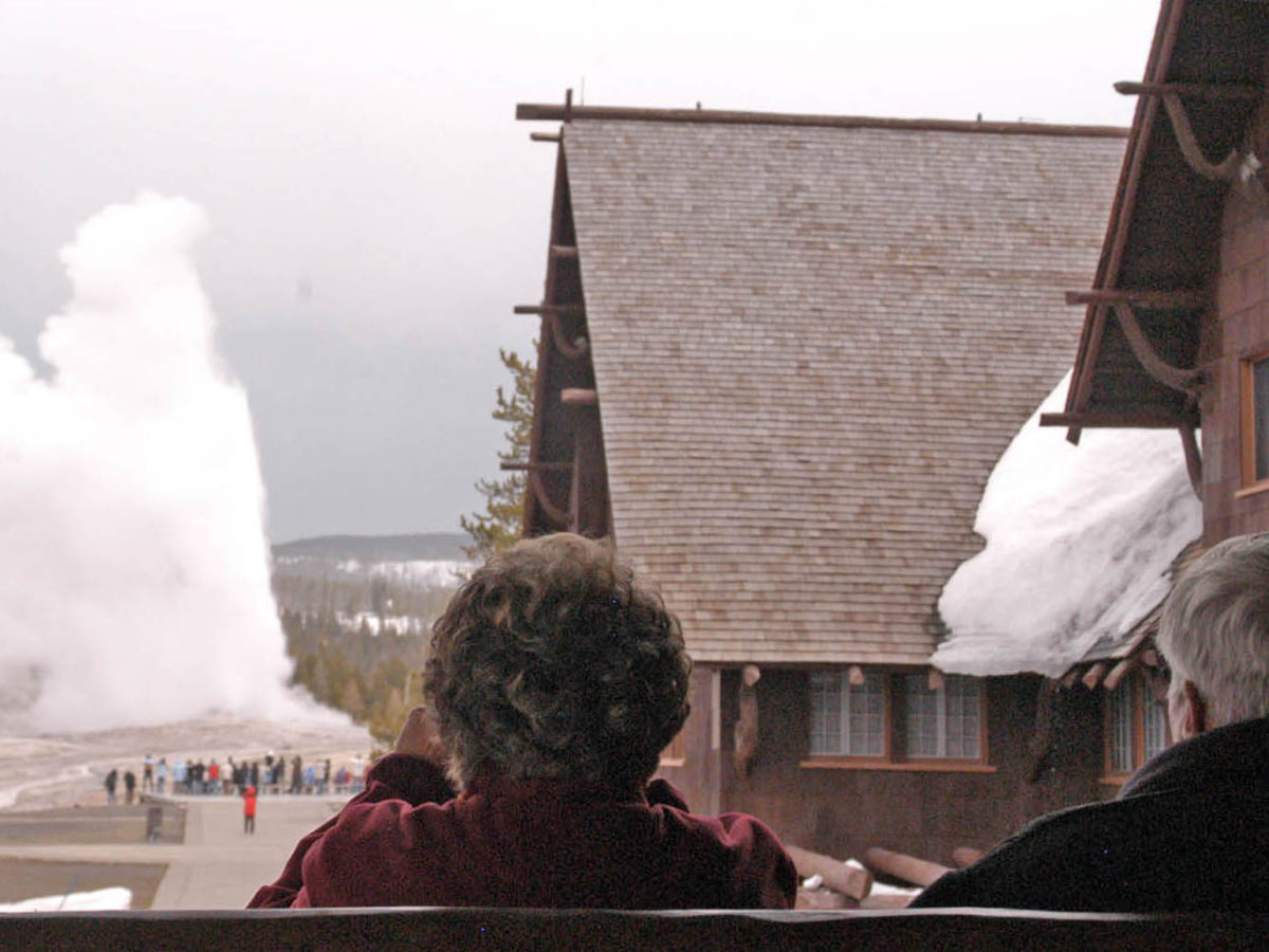 Visitors watch Old Faithful geyser erupt from a second-floor observation deck at the Old Faithful Inn. (Ruffin Prevost/Yellowstone Gate - click to enlarge)