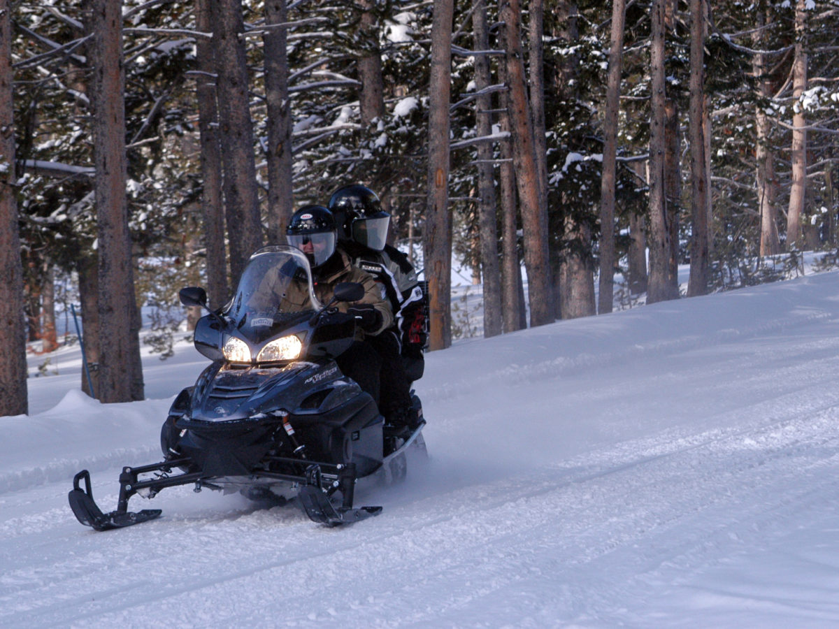 Two people share a snowmobile during a January 2012 trip into Yellowstone National Park.