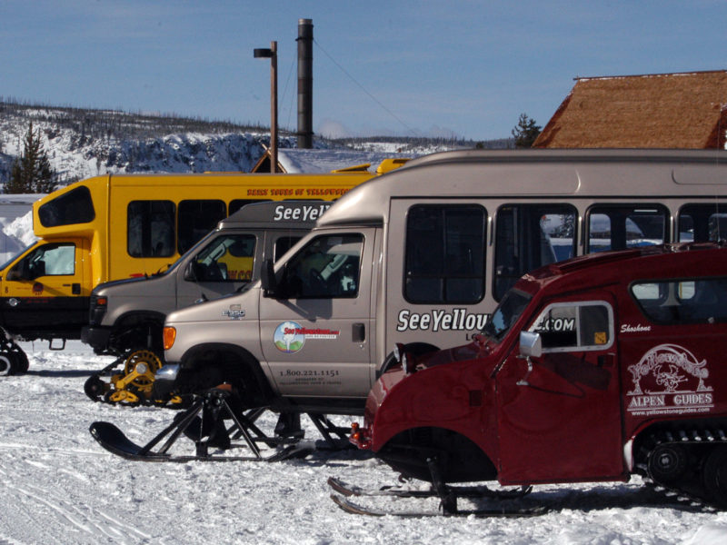 Snow coaches are parked near the Old Faithful Visitor Center in Yellowstone National Park.