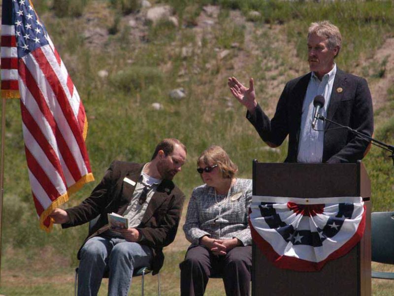 Bill Berg speaks during the Gardiner Gateway Project launch in Gardiner, Mont., sharing the stage with Daniel Bierschwale, President, Gardiner Chamber of Commerce and Clara Conner, Division Engineer, Western Federal Lands Highway Division. (Yellowstone Gate/Ruffin Prevost - click to enlarge)