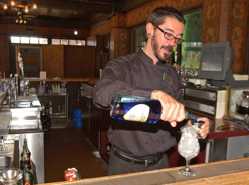 Topher Reimers tends bar at the Bear Pit in the Old Faithful Inn in Yellowstone National Park. Reimers had worked for six years in the park when this photo was taken in June 2006. (Ruffin Prevost/Yellowstone Gate file photo)