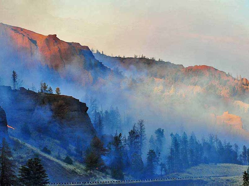 Smoke and sunlight create deep, surreal colors during the 2008 Gunbarrel Fire, which burned along the eastern boundary of Yellowstone National Park.