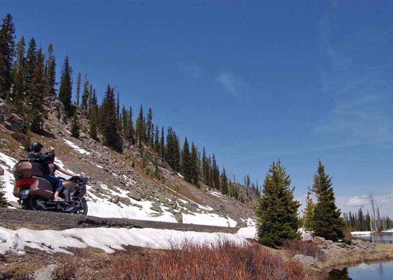 A motorcycle passes between the base of Talus Slope and the Lewis River in Yellowstone National Park. (Yellowstone Gate file photo/Ruffin Prevost - click to enlarge)