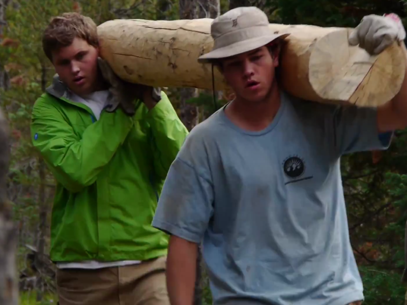 Participants in the Grand Teton National Park Youth Conservation Program move a log during a trail project.