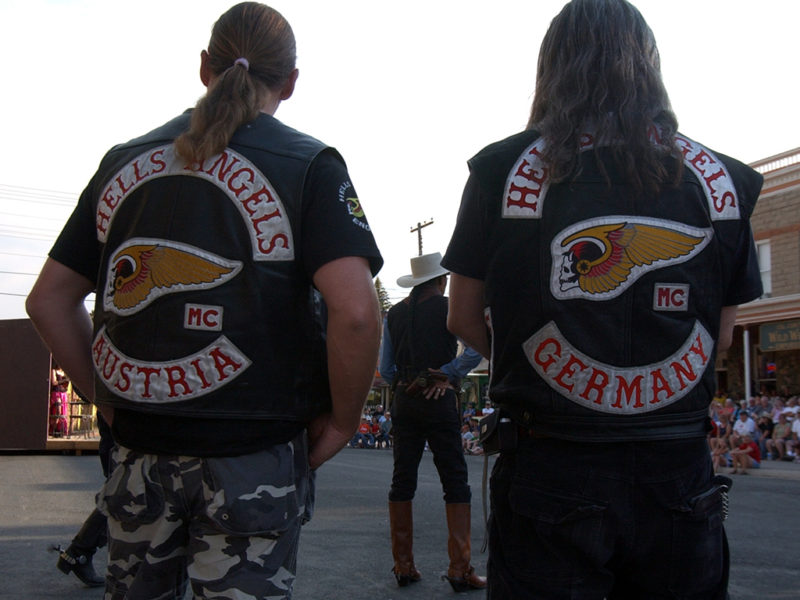 A Hells Angels motorcycle club member from Austria and one from Germany watch a mock gunfight at the Irma Hotel in Cody, Wyo. during the group's 2006 World Run this week.