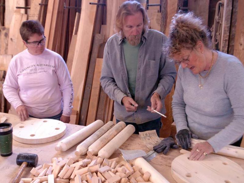 Liz Holmes, left, looks on as furniture designer John Gallis helps Hilary Heminway build a stool during a 2008 workshop as part of the Cody High Style show. Gallis coached a dozen students at his Norseman Designs West workshop on how to create a stool in the style of Western design pioneer Thomas Molesworth.