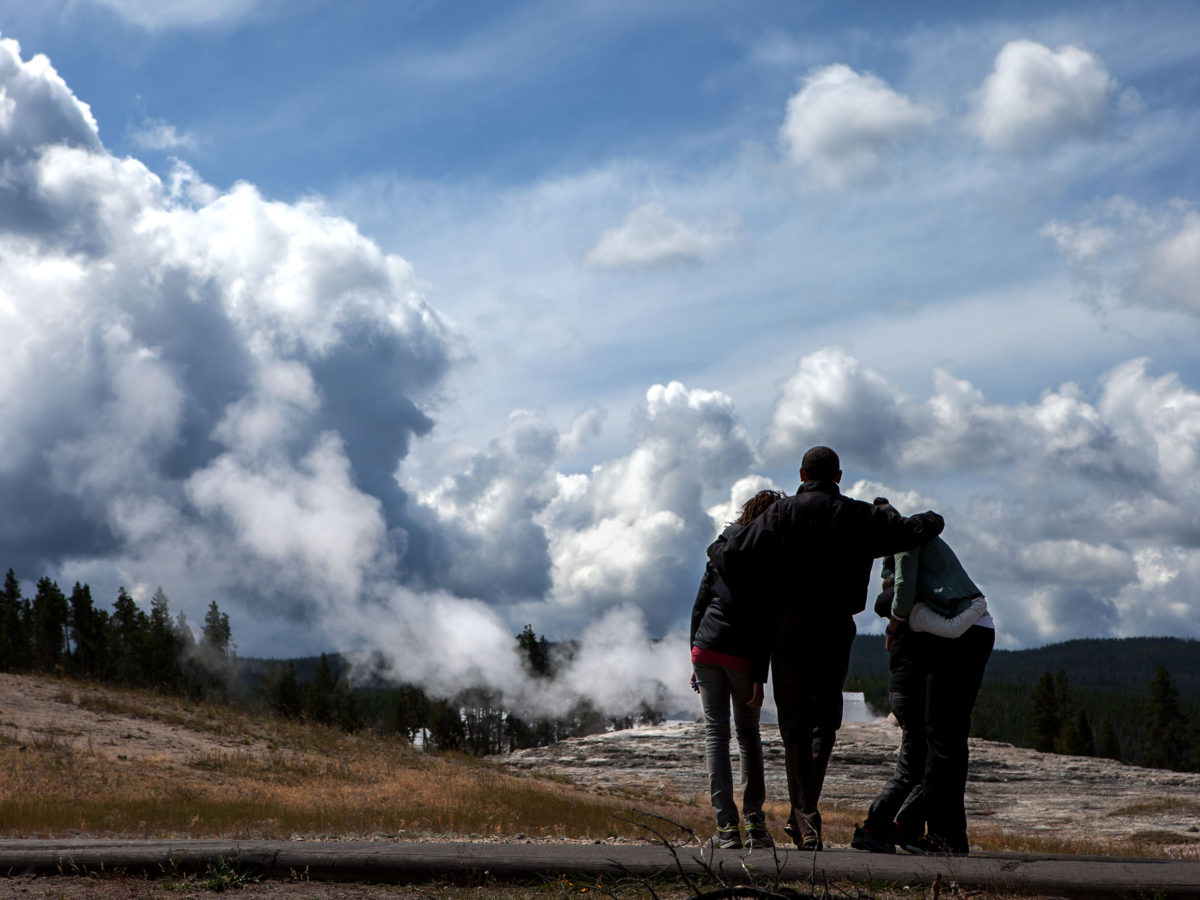 President Barack Obama awaits the eruption of Old Faithful with First Lady Micelle Obama and daughters Sasha and Malia during a 2009 visit to Yellowstone National Park.