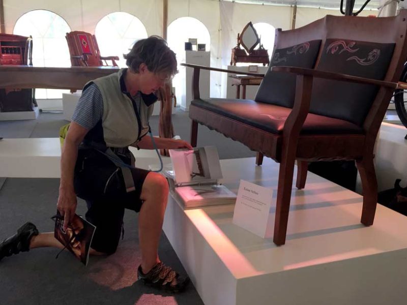 Western design enthusiast Peggy Ruble examines, Teton Settee, created by John Gallis of Norseman Designs West.