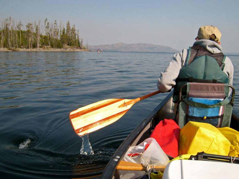 A canoeist paddles along the southeast arm of Yellowstone Lake in Yellowstone National Park.