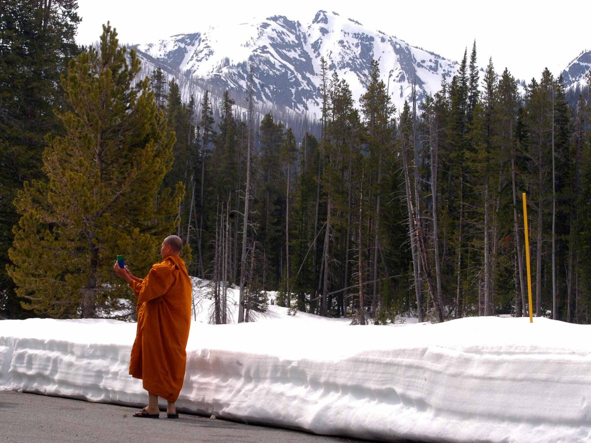 A Buddhist monk from Thailand takes photographs at Sylvan Lake on Friday in Yellowstone National Park.