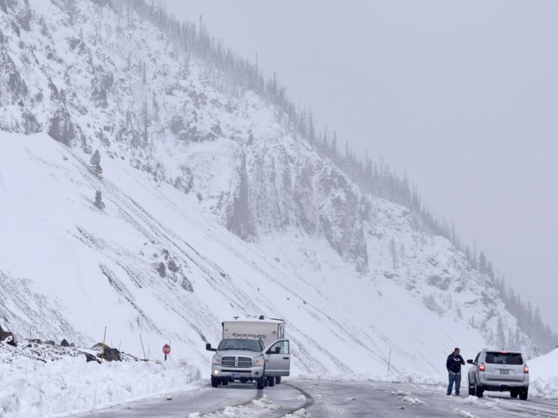 Two motorists pause at a pull-out atop Sylvan Pass to discuss snowy road conditions Tuesday in Yellowstone National Park.