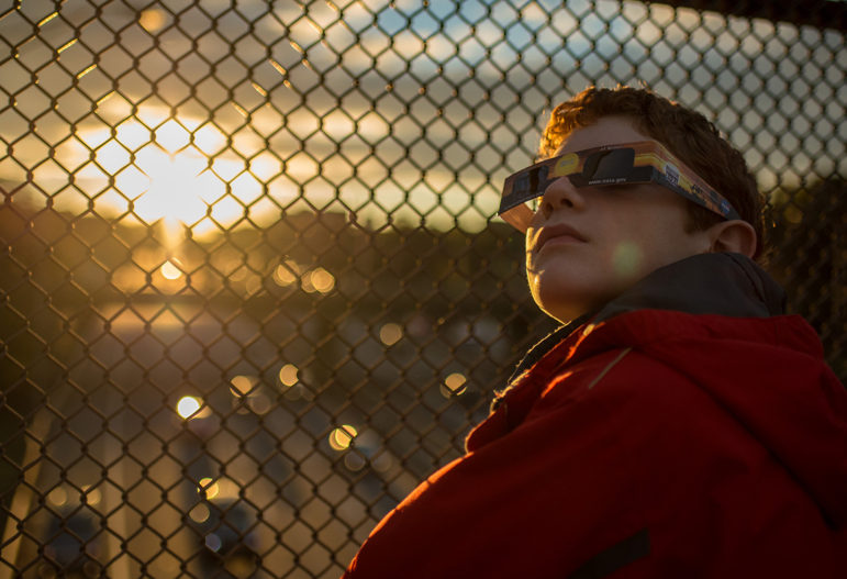 Alex Frye, 12, checks his special viewing glasses prior to viewing the partial solar eclipse from a highway overpass in Arlington, VA, Thursday, Oct. 23, 2014. (Image: NASA)