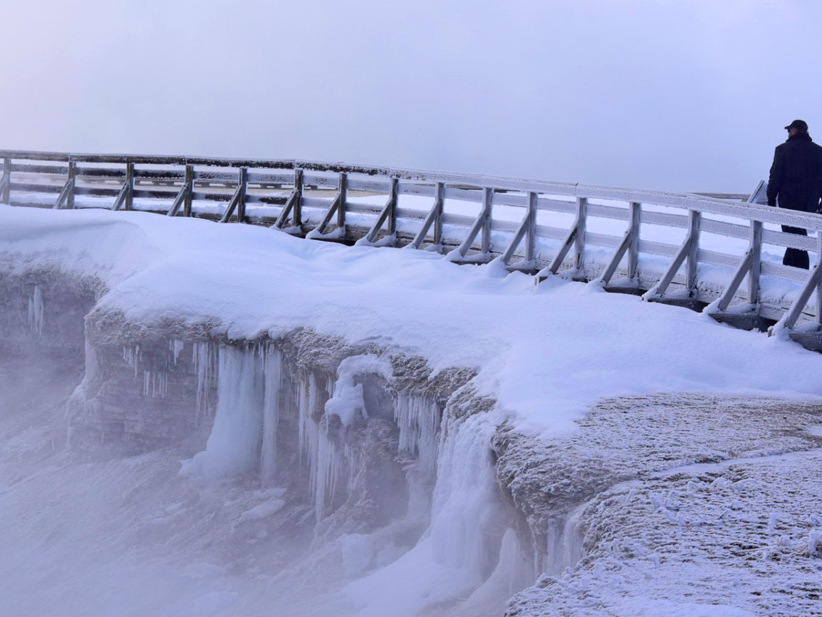 Visitors traverse the snow-covered boardwalk along Excelsior Geyser Crater in Yellowstone National Park. Private businesses have pitched in to keep the park open during the partial government shutdown .